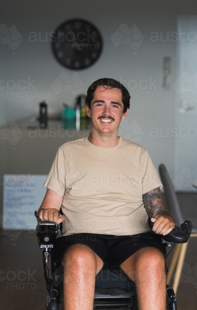 disabled man in wheelchair at home - Australian Stock Image