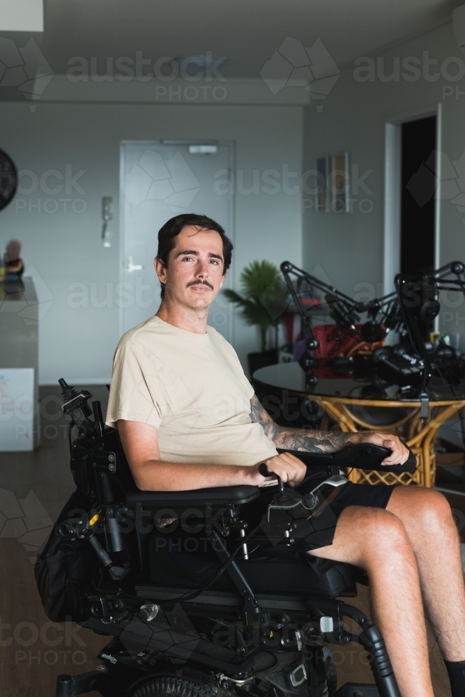 disabled man in wheelchair at home - Australian Stock Image