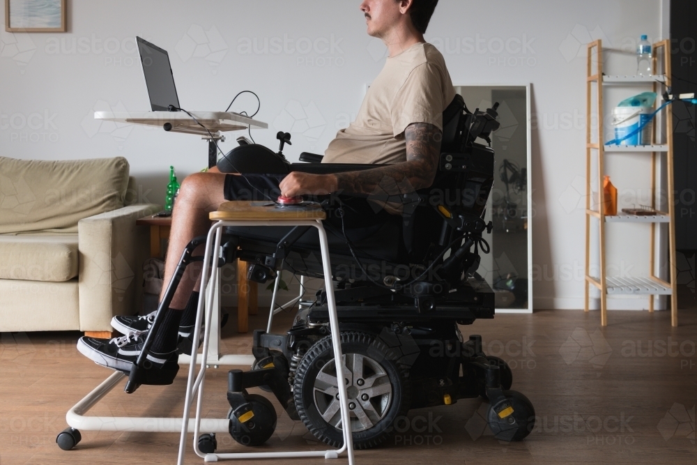 disabled man using computer, with special adaptive devices - Australian Stock Image