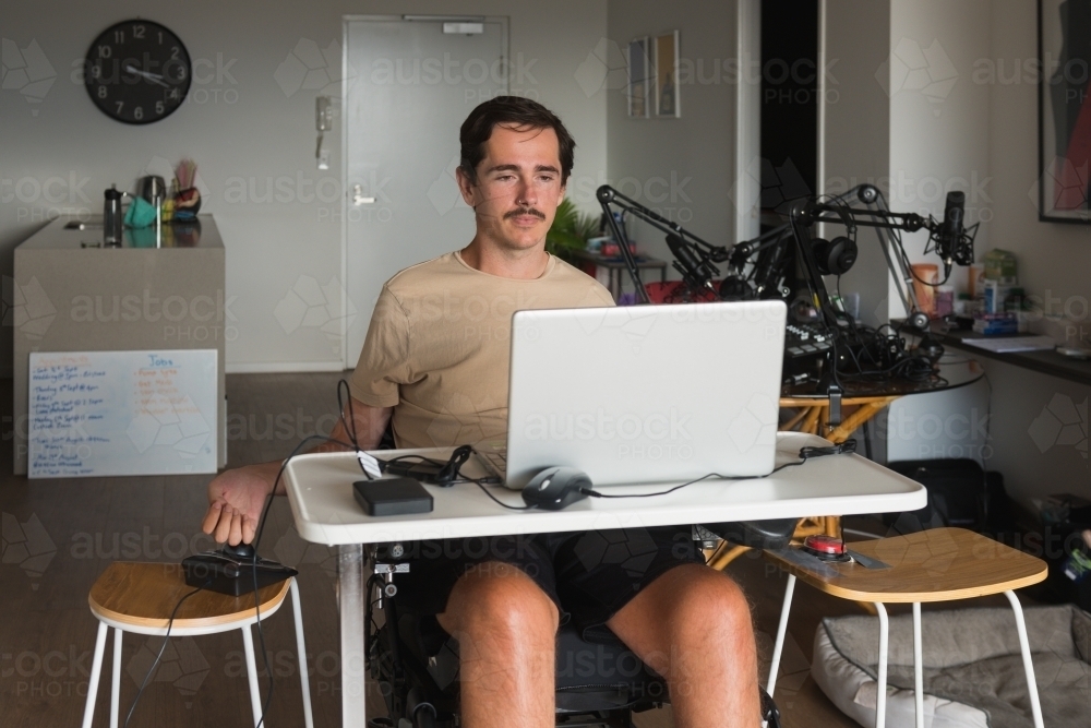 disabled man using computer, with special adaptive devices - Australian Stock Image