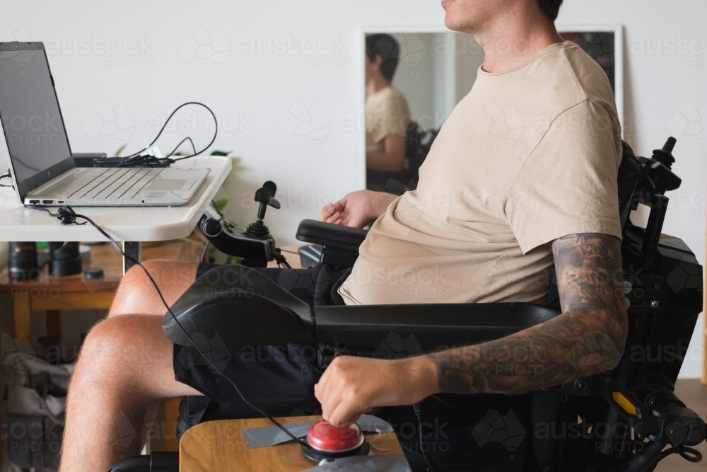 disabled man using computer, with special adaptive devices - Australian Stock Image