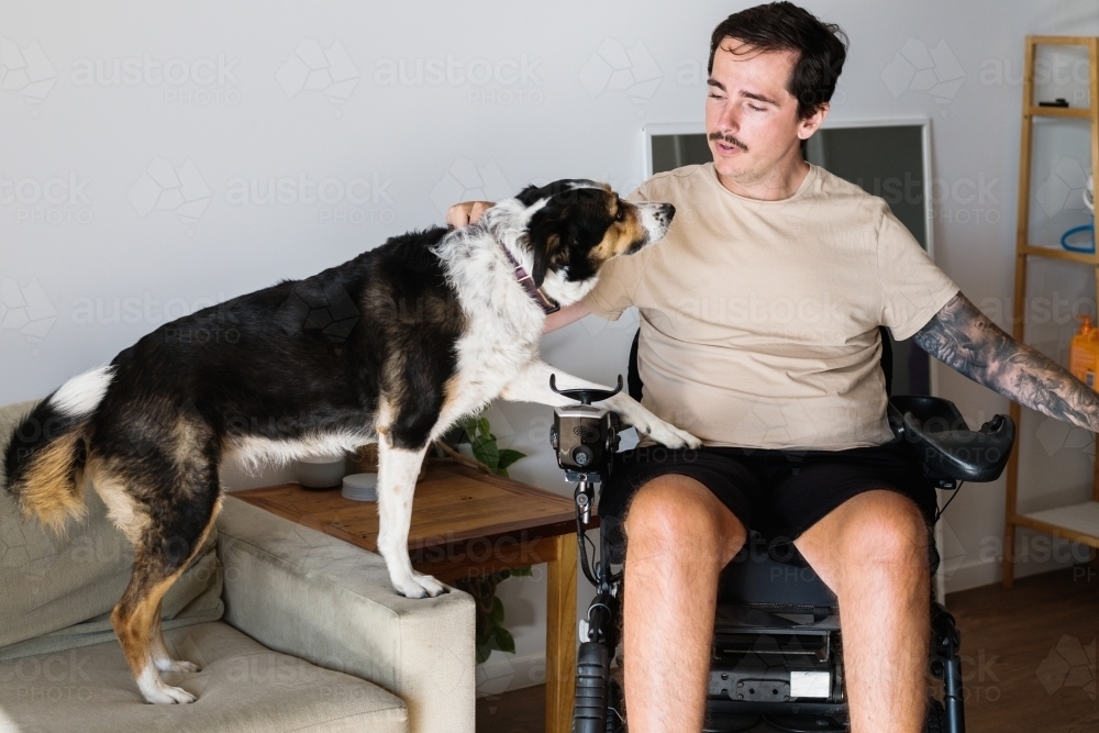 disabled man with his dog at home - Australian Stock Image