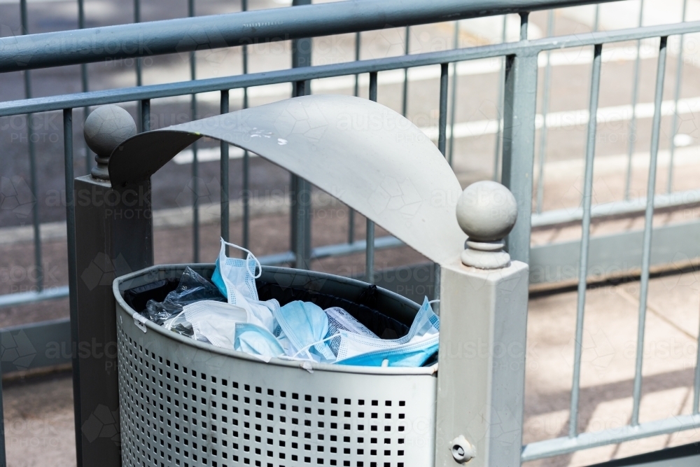 Discarded medical masks in bin outside hospital - Australian Stock Image