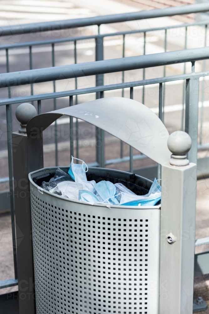 Discarded medical masks in bin outside hospital - Australian Stock Image
