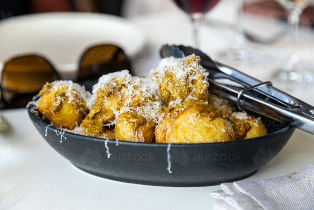 dish of potatoes with dressing and cheese - Australian Stock Image