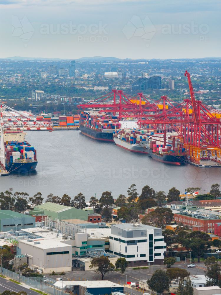 Image of Distant aerial view of cargo ships at port under large gantry ...
