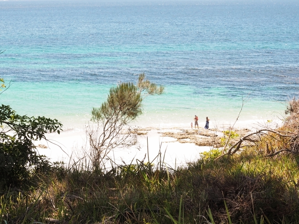 Distant family on beach in Jervis Bay - Australian Stock Image