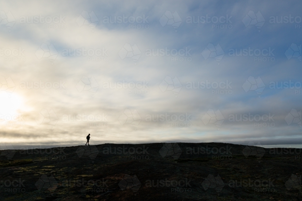 Distant figure silhouetted on horizon - Australian Stock Image