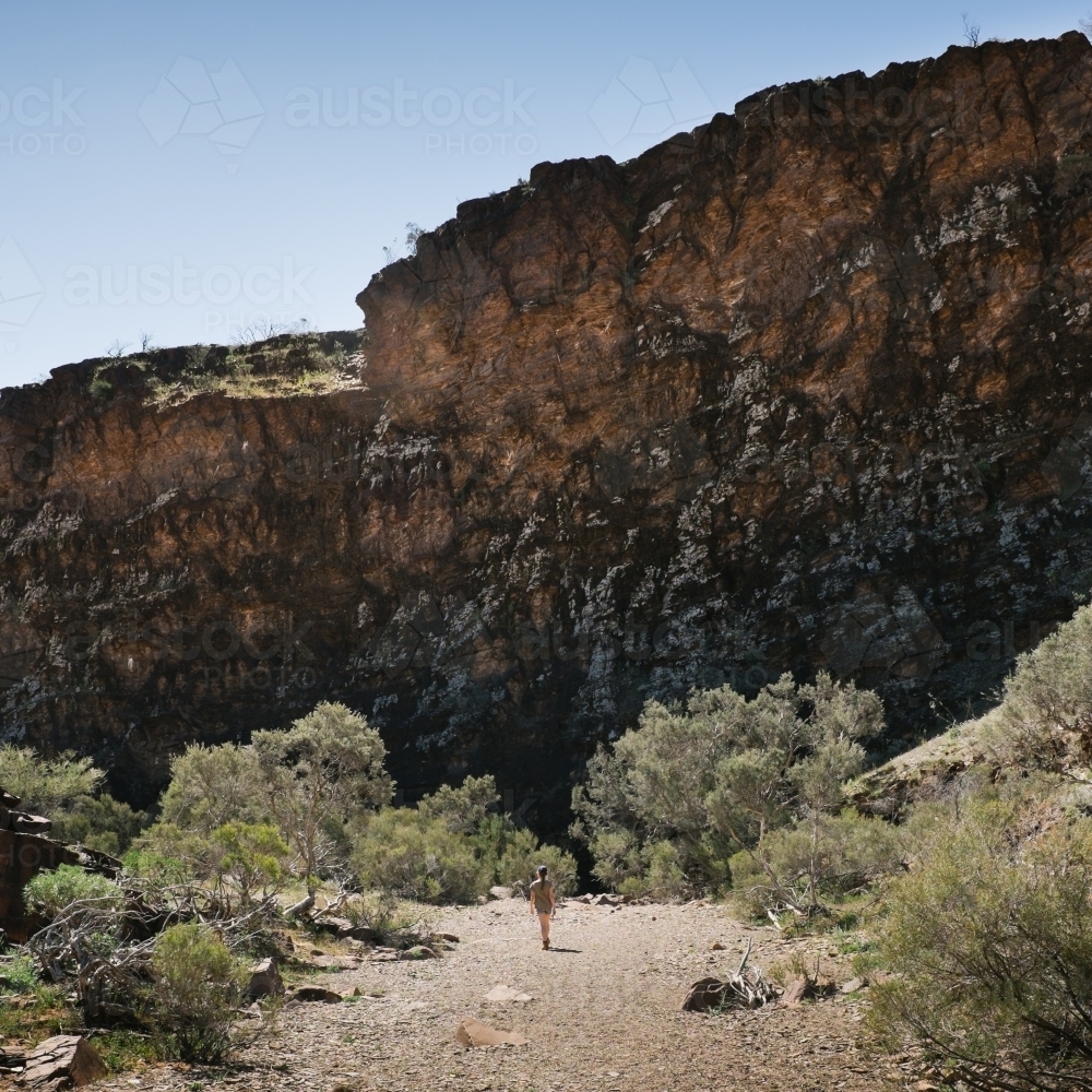 Distant figure walking in a remote rocky landscape - Australian Stock Image