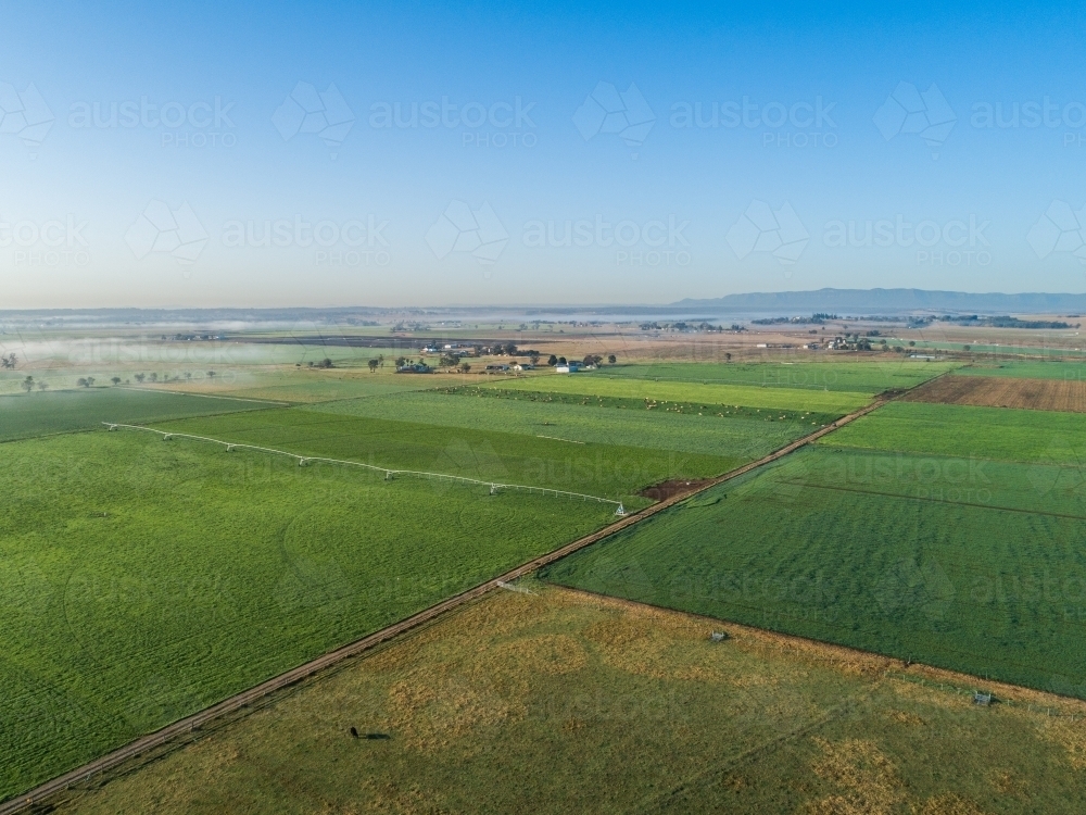 Distant mist on horizon with aerial view over agricultural farm land - Australian Stock Image