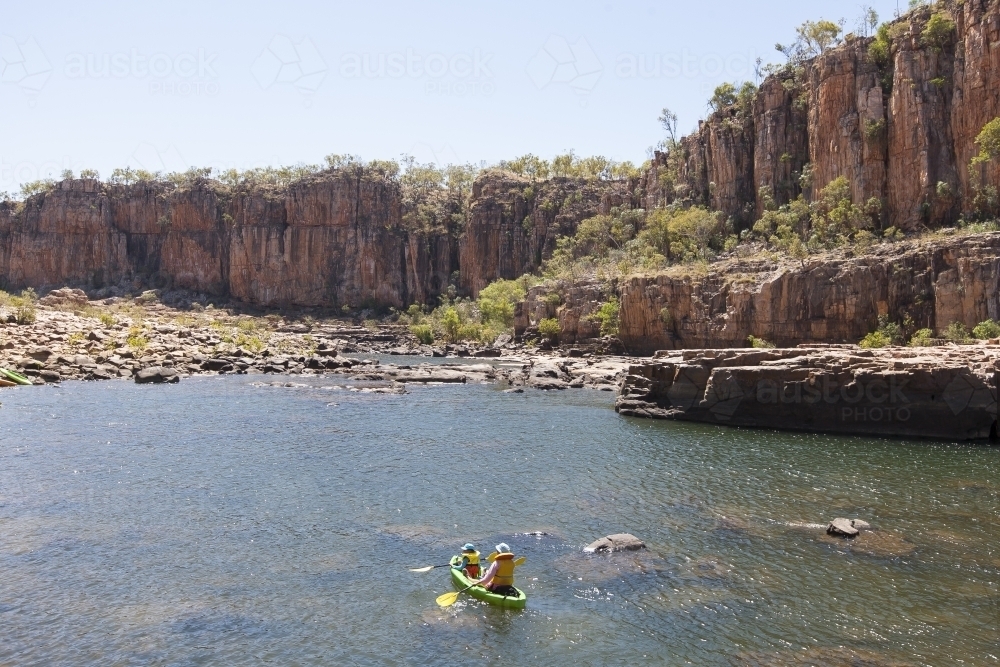Distant people kayaking at Nitmiluk National Park - Australian Stock Image