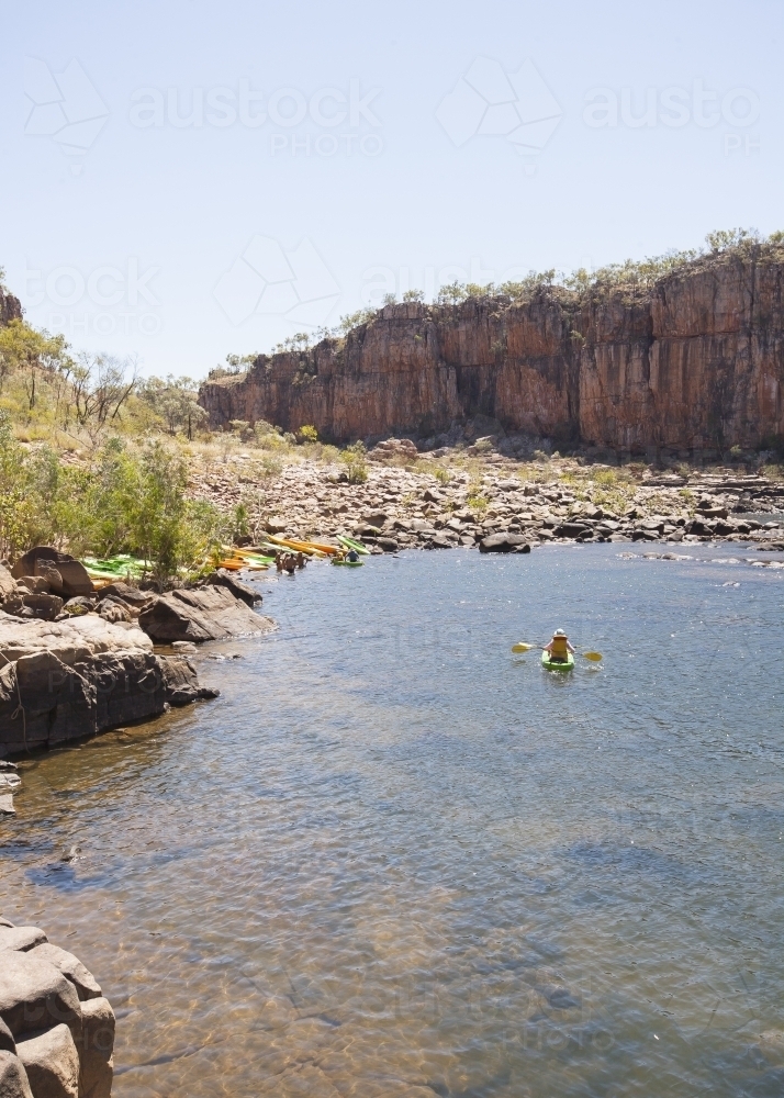Distant people kayaking at remote gorge - Australian Stock Image