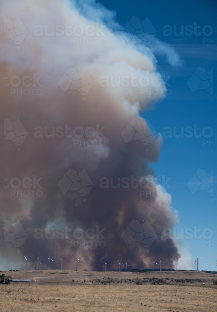 Distant wind turbines in front of towering bushfire smoke cloud - Australian Stock Image