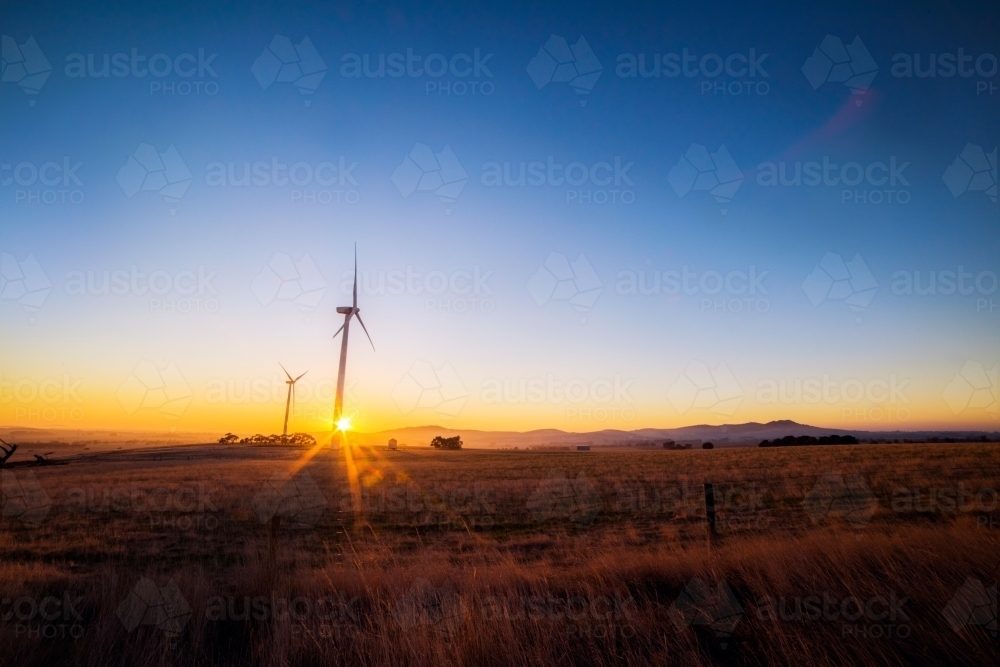 Distant wind turbines on a wind farm at sunrise. - Australian Stock Image