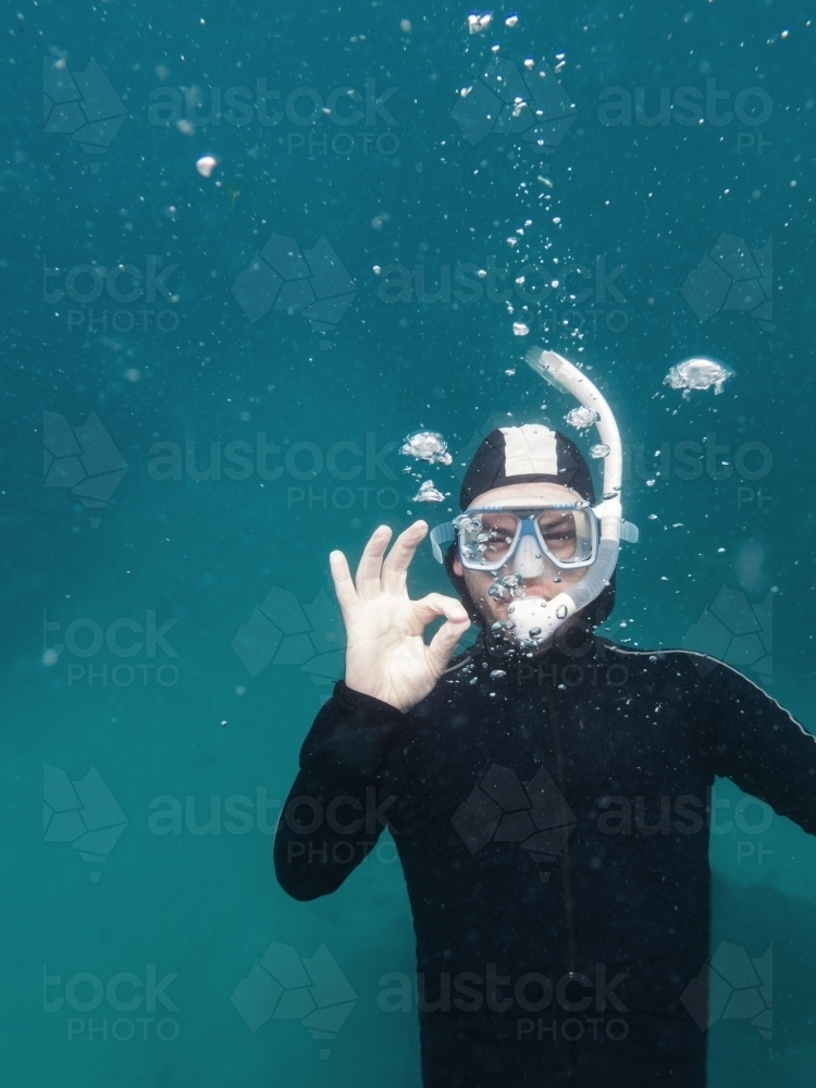 Diver under water signalling he is ok via a hand gesture - Australian Stock Image