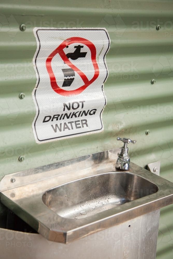 Do Not Drink Water sign above basin outside roadside toilet - Australian Stock Image