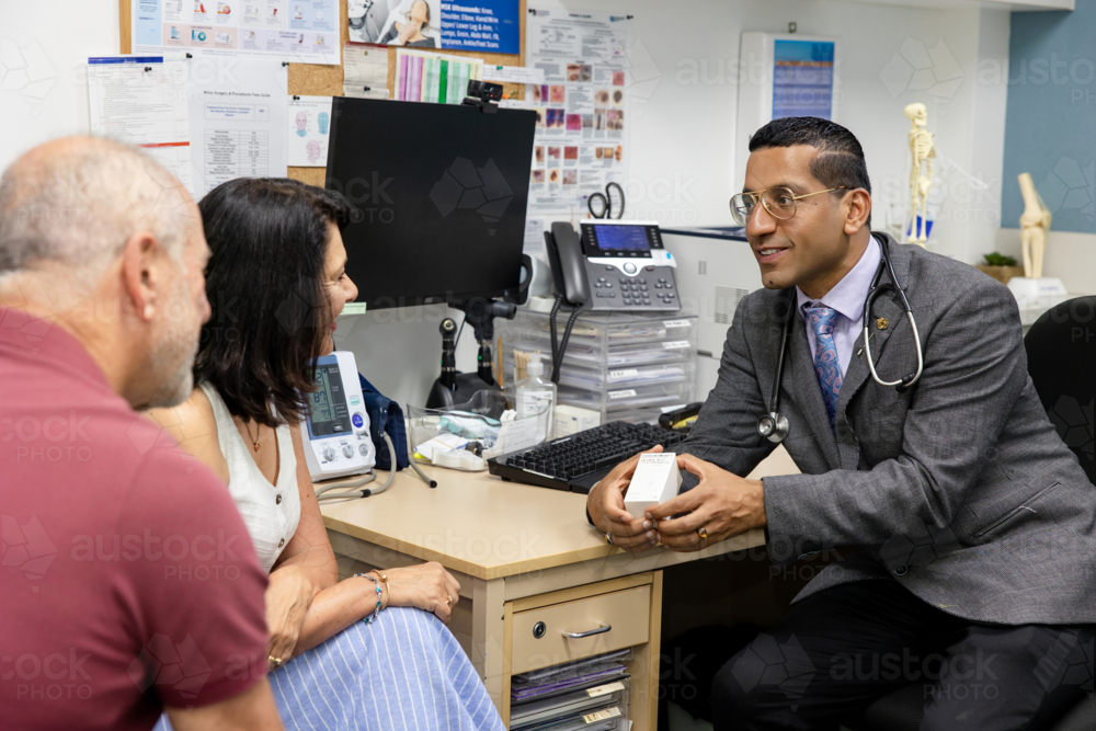 Doctor handing prescription medicine to female patient - Australian Stock Image