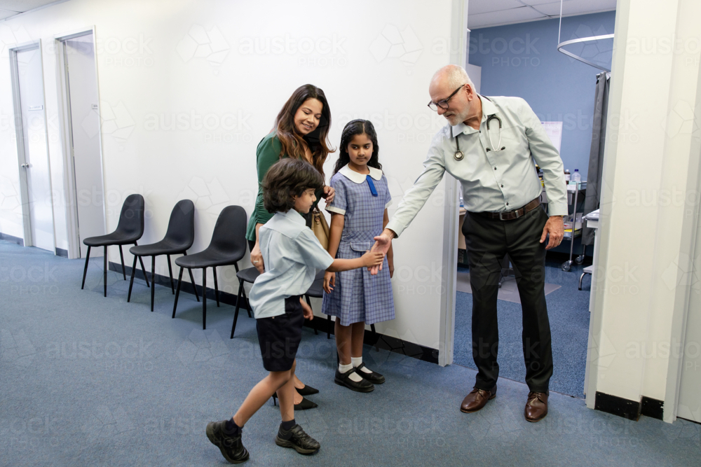Doctor meeting family outside office - Australian Stock Image