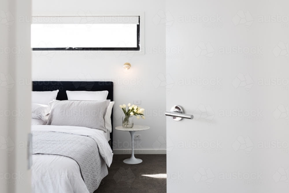 Door opening to reveal a luxury master bedroom - Australian Stock Image