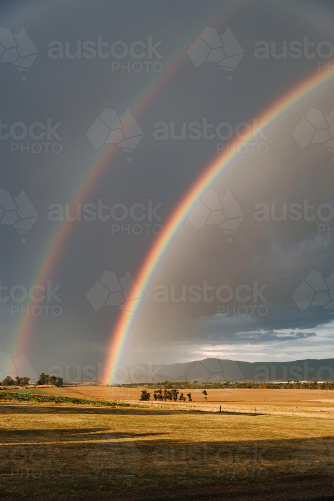 Double rainbow arching over a vast farmland - Australian Stock Image