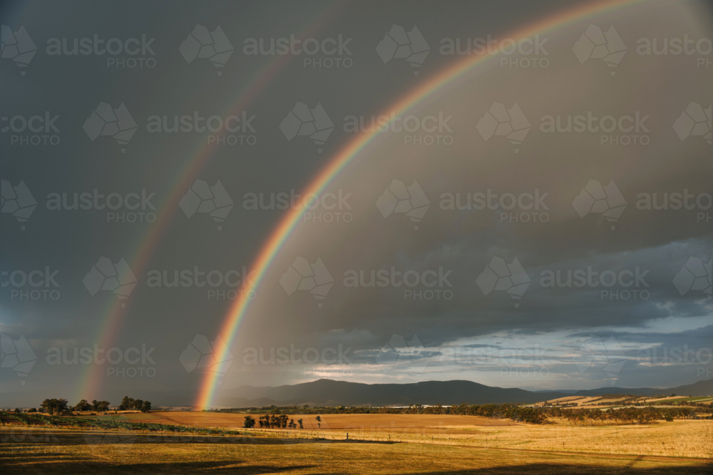 Double rainbow arching over a vast farmland - Australian Stock Image