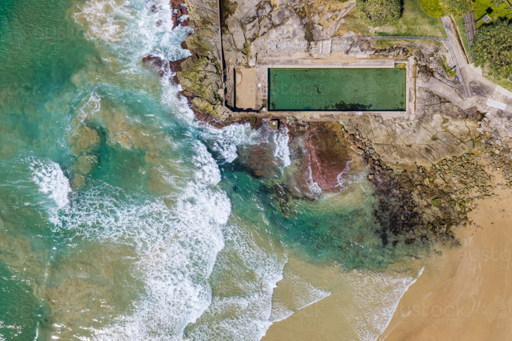 Downward aerial view of Yamba Main Beach and the ocean pool, showing the sandy shore - Australian Stock Image