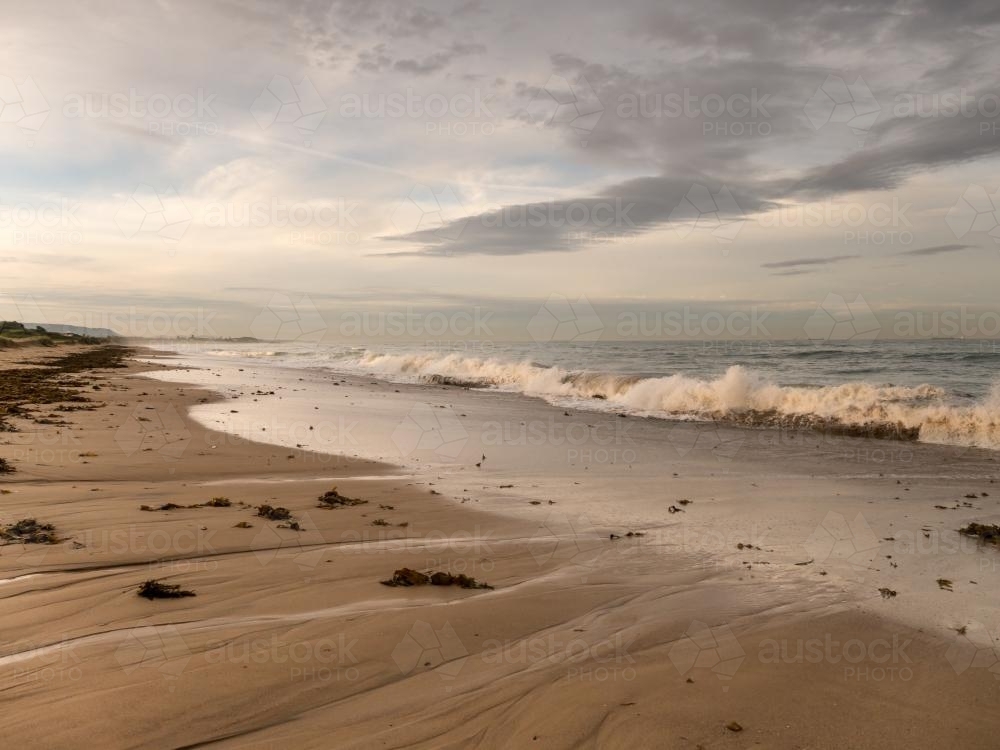 Dramatic beach draining back into the breaking surf - Australian Stock Image