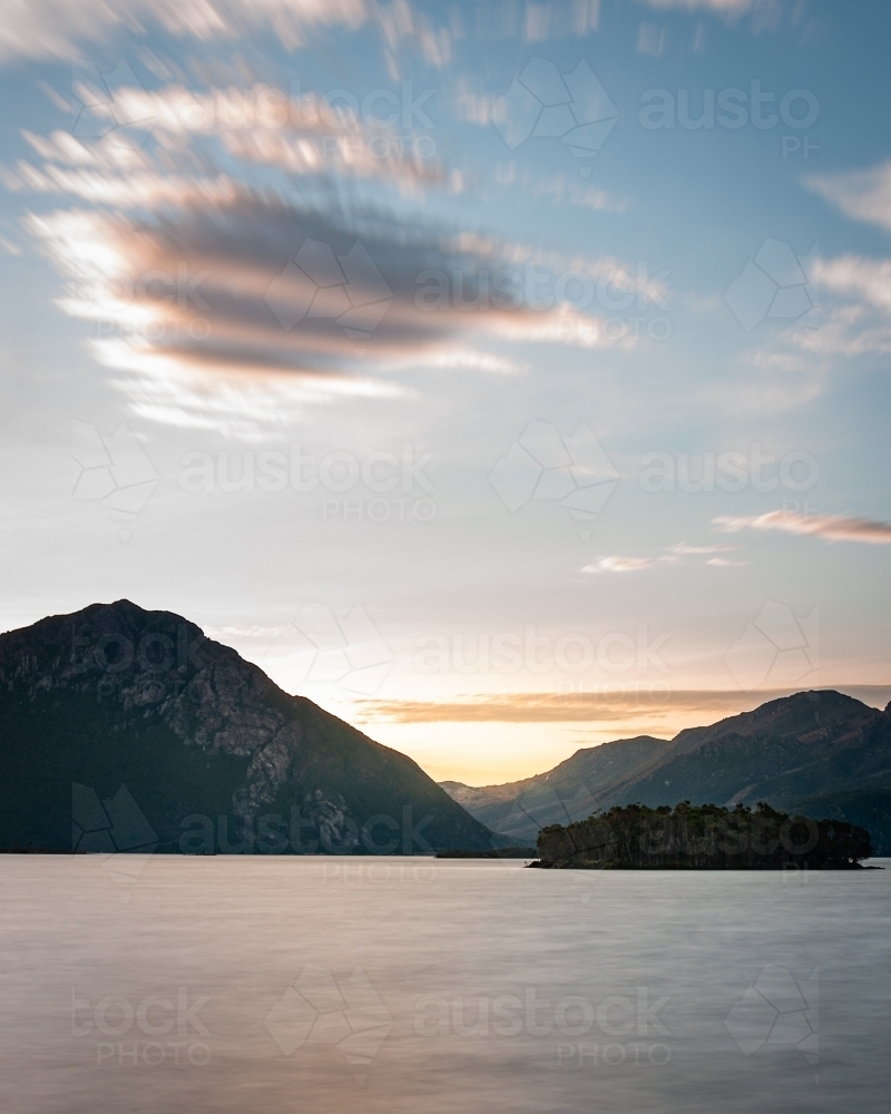 Dramatic Clouds Above a Rugged Mountain Range and Lake in Queenstown Tasmania - Australian Stock Image