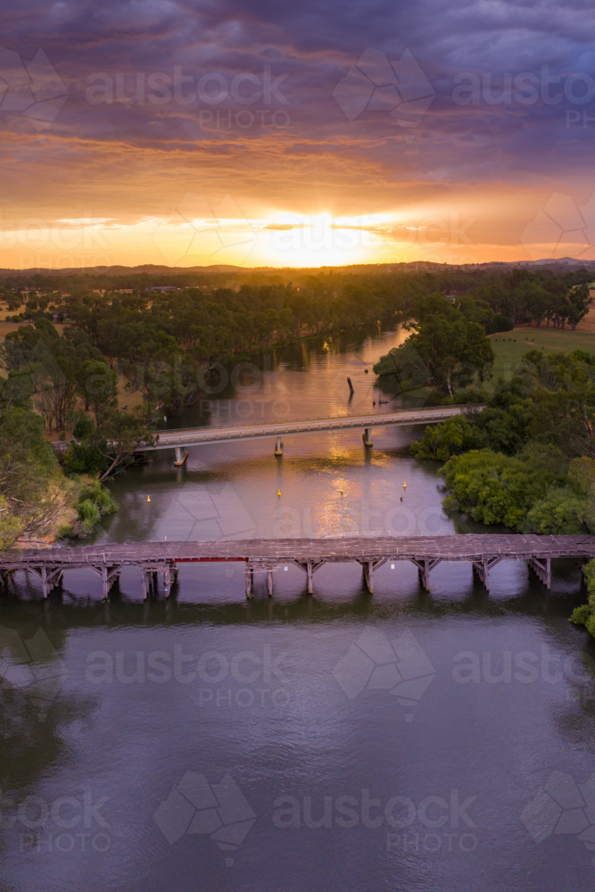 Dramatic colourful sunset over bridges on an inland river - Australian Stock Image
