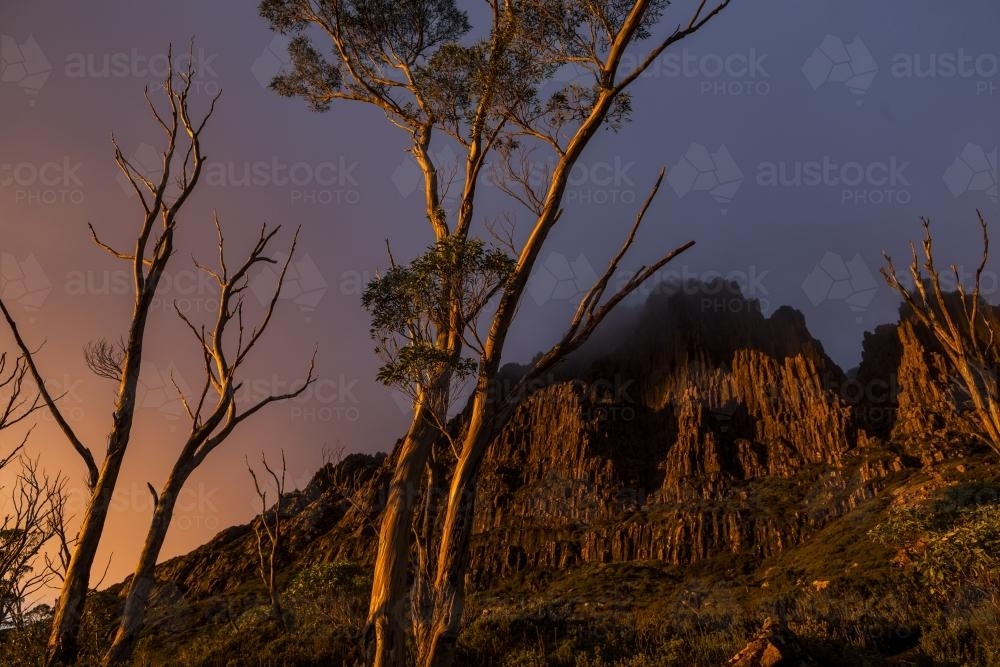 Dramatic sunset across the jagged flanks of Cradle Mountain - Australian Stock Image