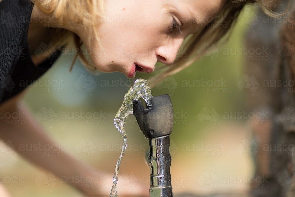 Drinking water from bubbler fountain - Australian Stock Image
