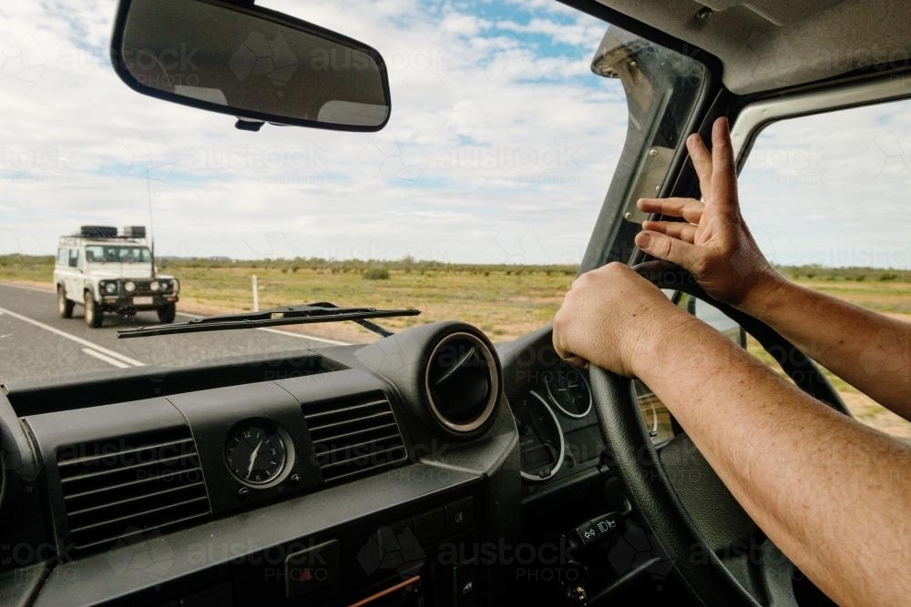 Driver waving to another 4 wheel drive in outback Australia - Australian Stock Image