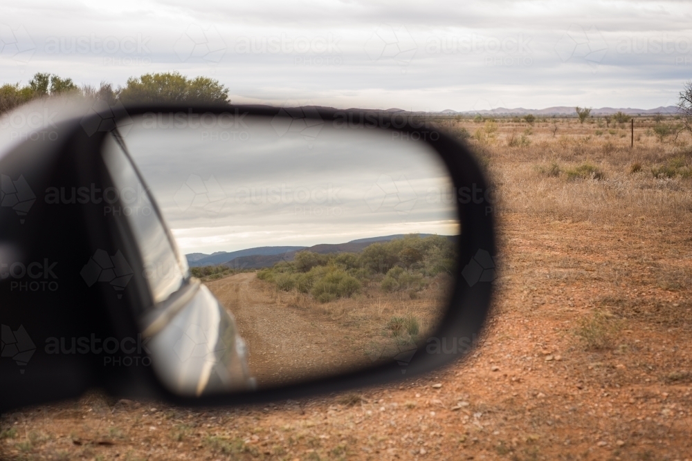 Driving, looking at reflection in side window of remote country - Australian Stock Image