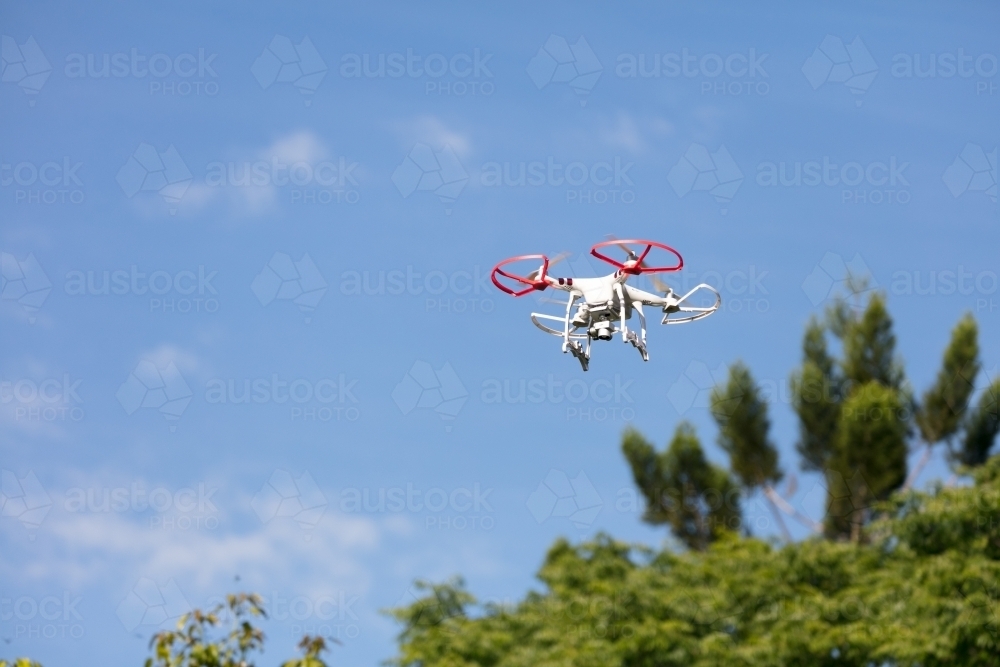 Drone aircraft hovering above trees - Australian Stock Image