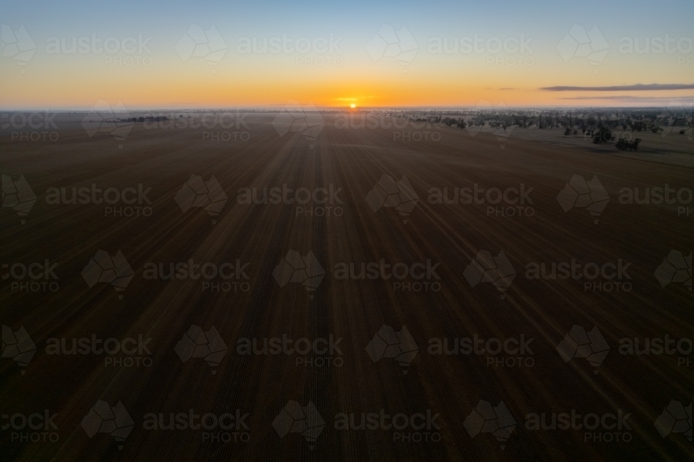 Drone shot of low sun over empty field - Australian Stock Image