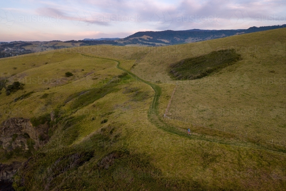 Drone Shot of Man Running on Hillside - Australian Stock Image