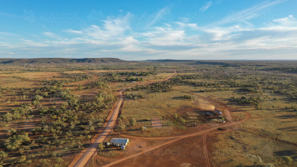 Drone shot of rural landscape, road and trucks loading cattle - Australian Stock Image