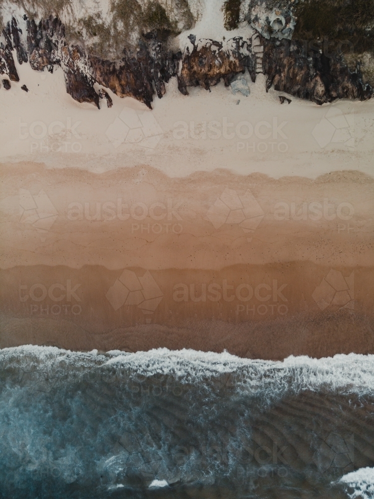 Drone shot of waves crashing on a beach from above - Australian Stock Image