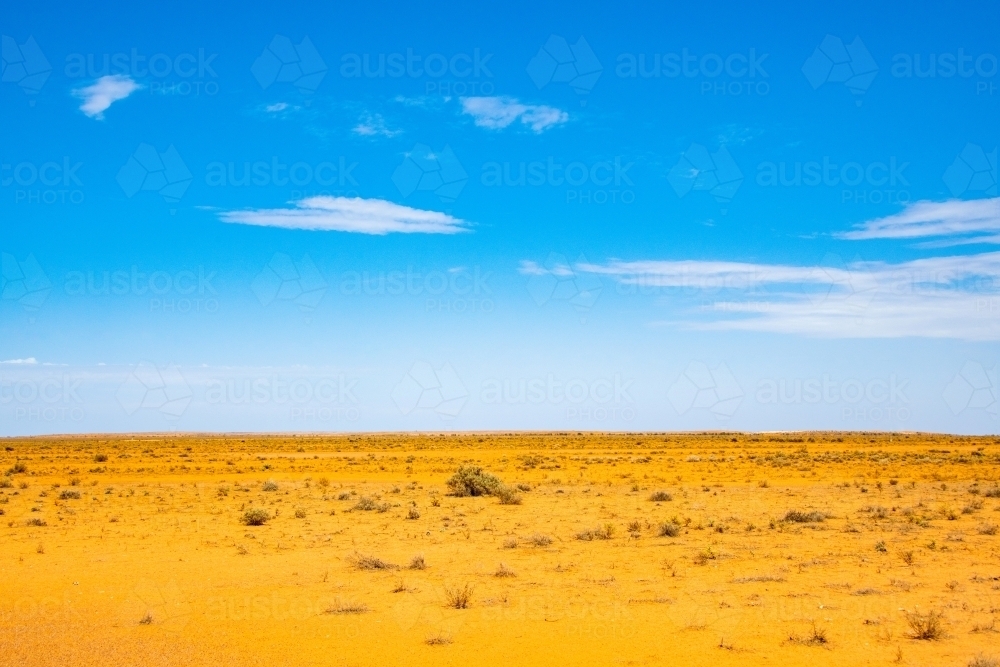 Image of Dry, barren, orange land against the blue sky. Austockphoto