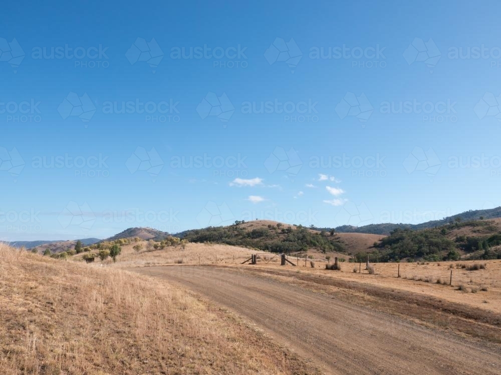 Dry summer countryside with brown grass and clear blue sky - Australian Stock Image