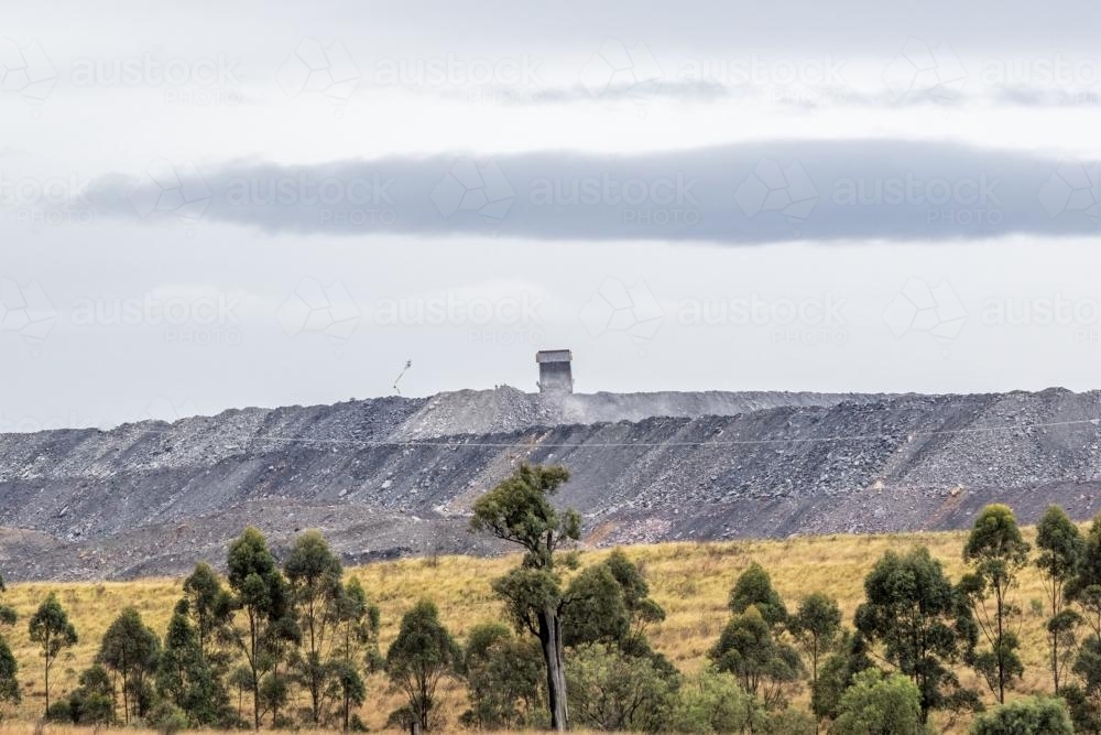 Dump truck dumping coal mine tailings in distance - Australian Stock Image