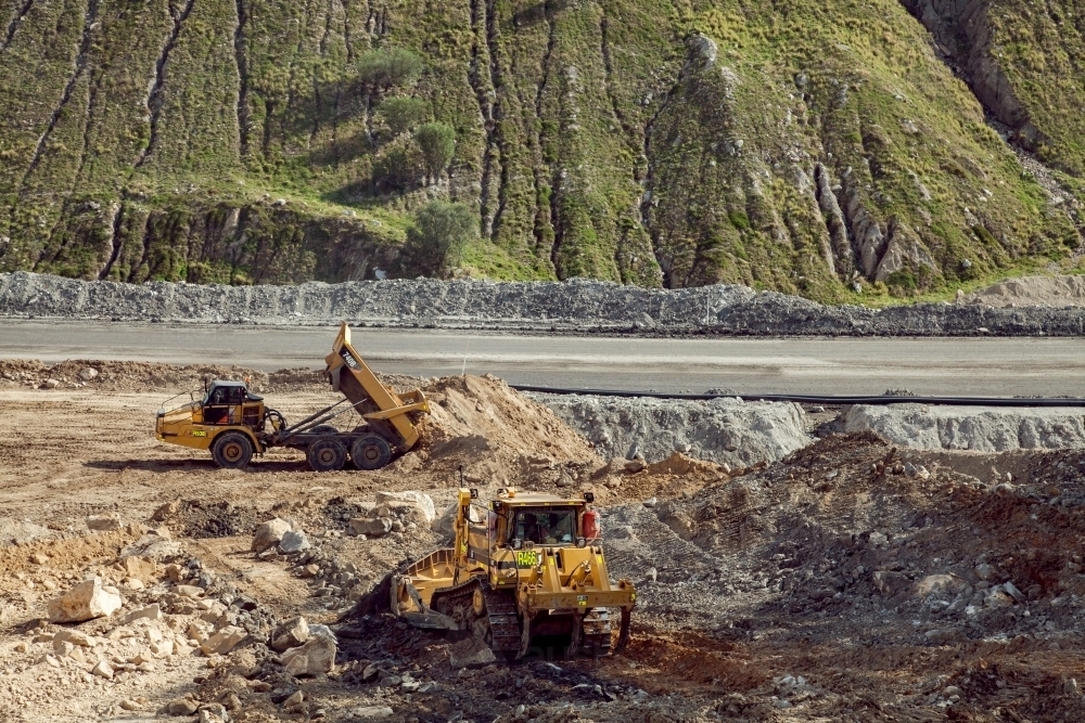 Dump truck moving dirt beside open cut mine - Australian Stock Image