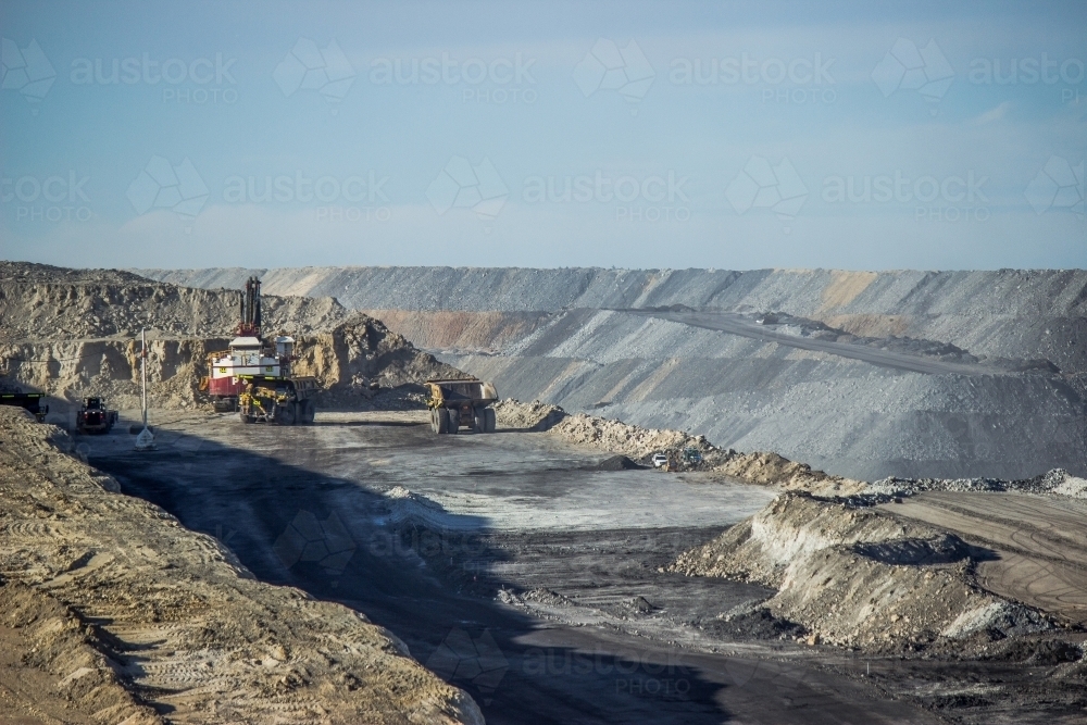 Dump trucks loading up with slag in open cut coal mine - Australian Stock Image
