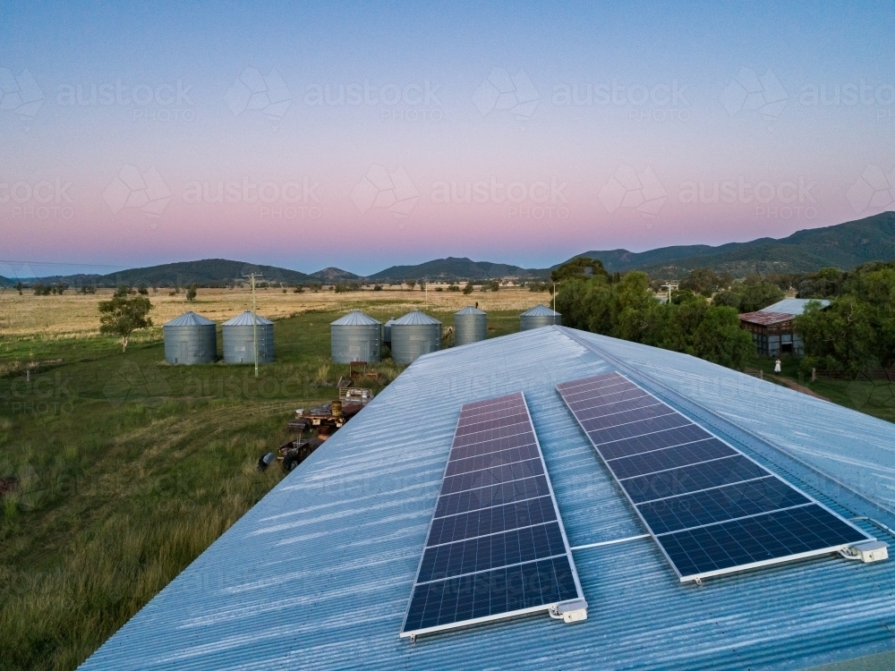 Dusk light on solar-powered farm shed harnessing renewable energy for sustainable agriculture - Australian Stock Image