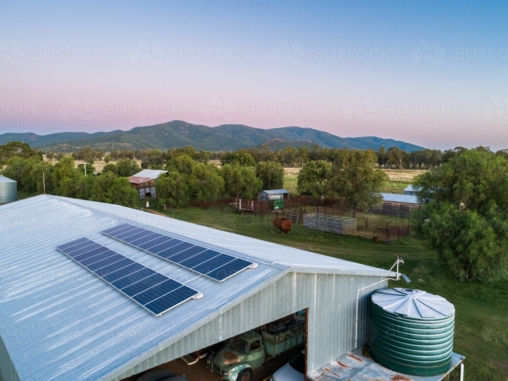 Dusk light on solar-powered farm shed harnessing renewable energy for sustainable agriculture - Australian Stock Image
