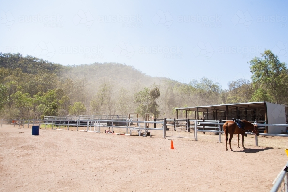 Dust blowing through paddock of riding school on hot day - Australian Stock Image