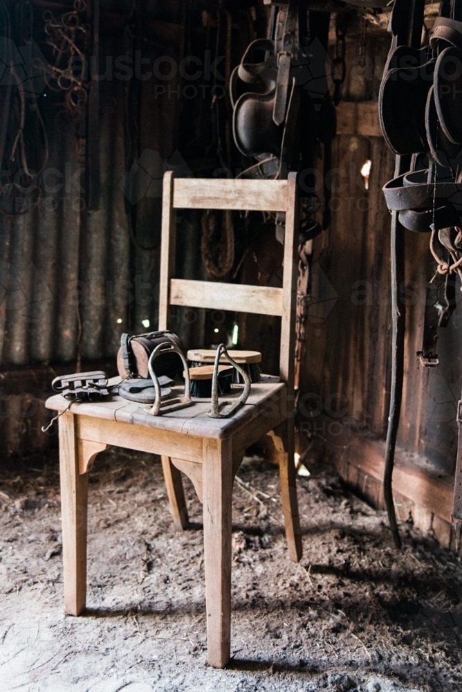 Dusty old items on a chair in a tack shed - Australian Stock Image