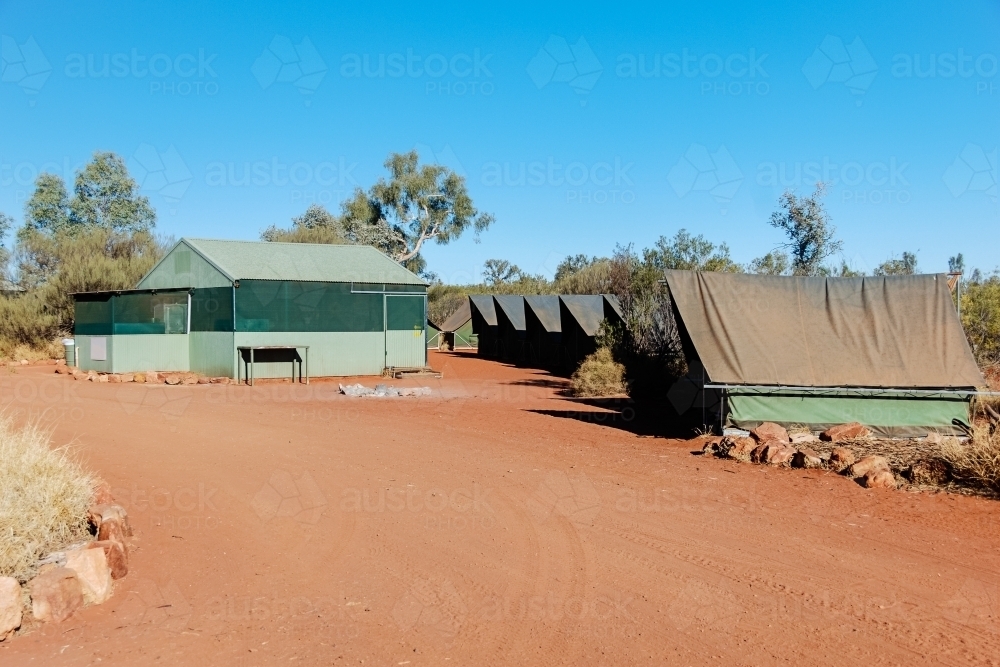 Dusty red dirt campsite in the outback with permanent tents - Australian Stock Image