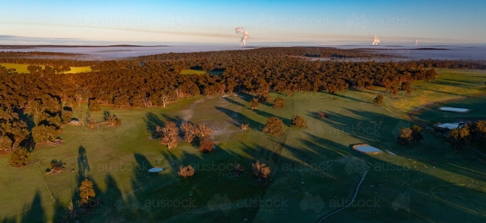 early morning fog over valley with clouds rising from distant power stations - Australian Stock Image