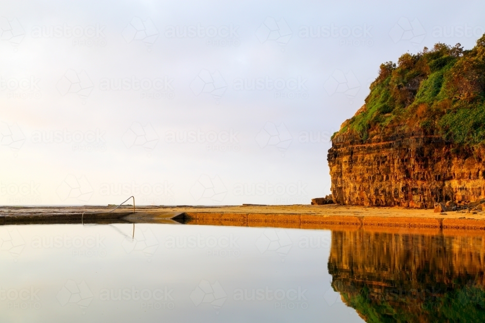 Early morning reflections in the Wombarra Rock Pool on the Illawarra Coast - Australian Stock Image